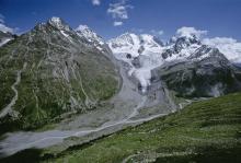 Proglacial margin of Vadret da Roseg, crossed by a brook. In the background, the Roseg glacier and the Bernina massif.